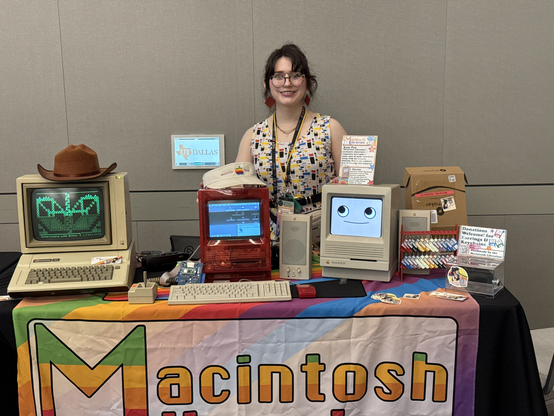 Macintosh Librarian at her booth at VCF SW with an Apple II, and a few Mac SE/30s.