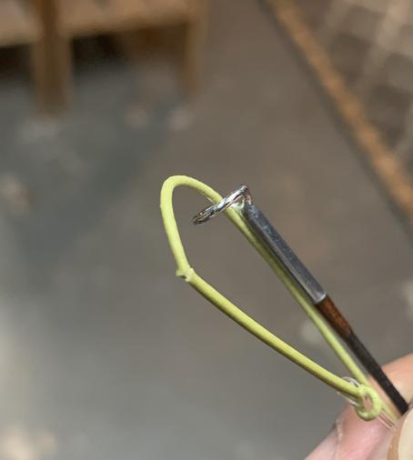 Zooming in a cracked moss green fly line sticking out of a fly rod tip.