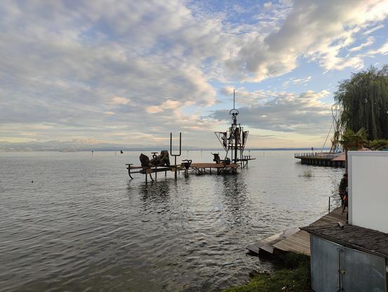 Das Kunstobjekt Klangschiff am Bodensee in Friedrichshafen im Wasser des Bodensee. Darüber blauer Himmel mit ein paar Wolken. Auf Grund des Hochwassers der letzten Wochen steht das Klangschiff vollständig im Wasser.