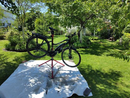 Fahrrad am Montageständer im Garten auf einer Plane