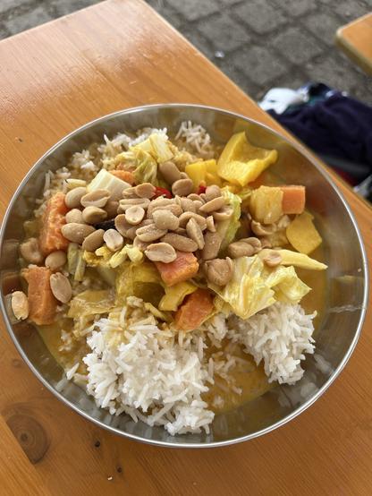 Teller mit Reis und Curry mit Erdnüssen drüber gestreut