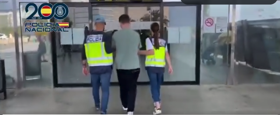 A still shot from a video released by Spanish national police showing them taking the defendant into custody at a Spanish airport as he tried to get on a flight to Italy.