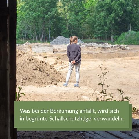 Eine Person von hinten. Sie hat die Hände auf dem Rüvcken und schaut über die Baustelle. Im Hintergrund sandige Flächen sowie Sand- und Betonbruchhügel.