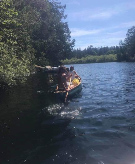 Paddling in canoe with a friend. On a lake. Sunny day.