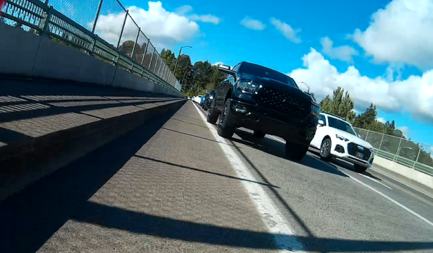 truck with no front license plate, slightly on the bike lane paint