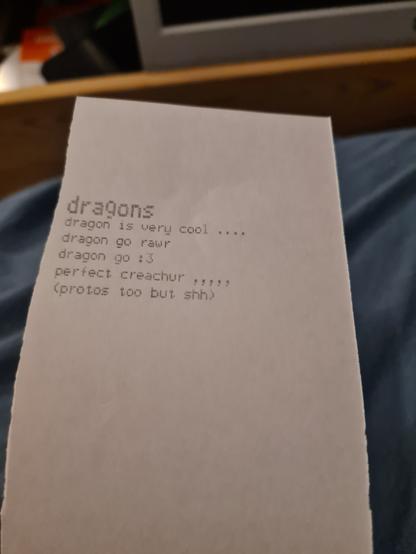 dot matrix printout saying
"dragons
dragon is very cool ....
dragon go rawr
dragon go :3
perfect creachur ,,,,,
(protos too but shh)"