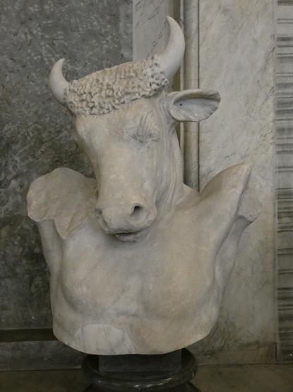 Bust of a minotaur: powerful bull's head, looking at the viewer, slender torso,: the missing arms raised (as if crucified) to emphasise the shoulders and musculature.