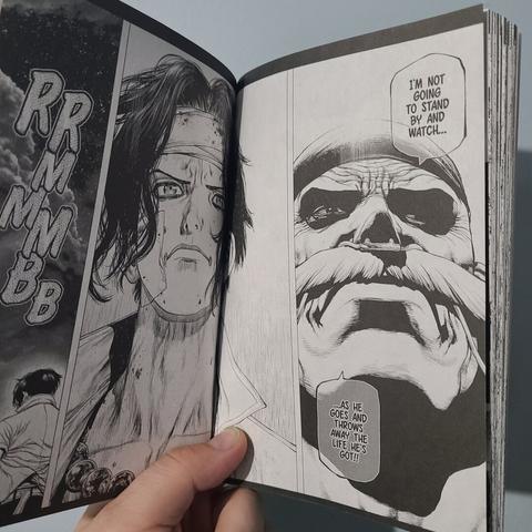 Photograph of the interior of Volume 2 of One Piece Ace's Story The Manga showing a black and white manga panel. The two panels show a zoom in on Whitebeard's face and Ace's face in side by side panels.