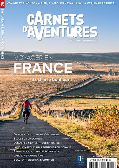 Couverture du magazine avec la photo d'un·e cycliste, de dos, dans un paysage de prairie automnal.