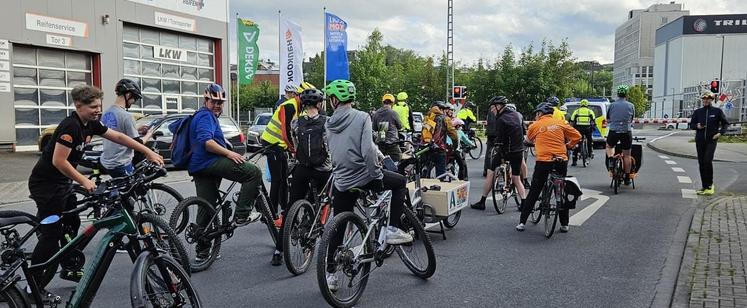 Radfahrer der Critical Mass vor einer geshlossenen Bahnschranke. Vorn ein Polizei-Bulli.
