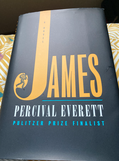 Cover of James: A Novel, Percival Everett, Pulitzer Prize Finalist. The cover is black with the word James in yellowish/amber. Percival Everett in gray; Pulitzer Prize Finalist in teal.