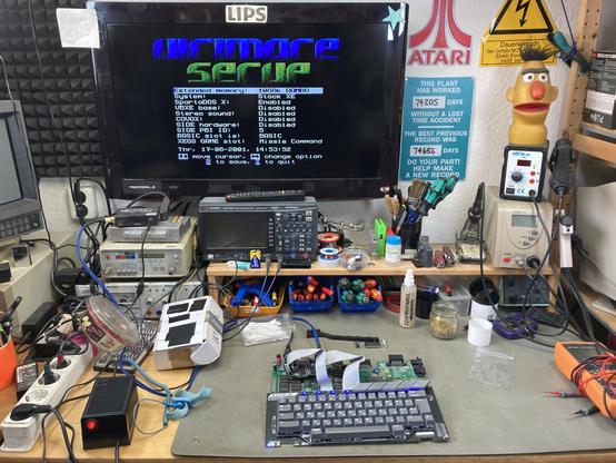 Atari XE board on my bench with the Decent XE keyboard attached and the setup menu from the Ultimate 1MB upgrade displayed on the screen.