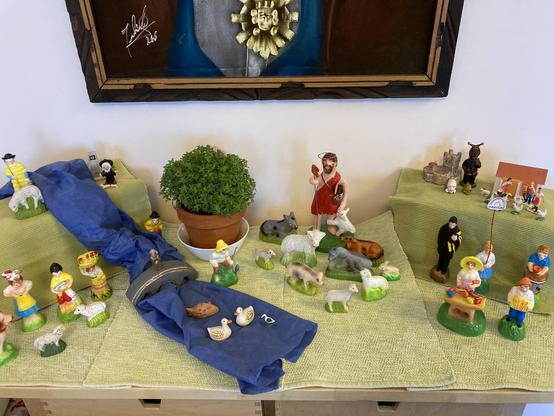 A "cascata" display of colorful hand-painted figurines on a landscape of green and blue cloth.