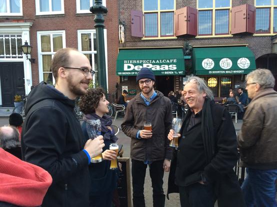 a photo of Frank Grießhammer, Alexandre Saumier-Demers, Susana Carvalho, and Jan Willem Stas enjoying a beer outside of De Paas bar in Den Haag.