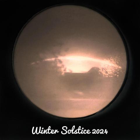 A sepia image with trees and low buildings. A low bright arc shows the path of the midwinter sun's passage through the day.