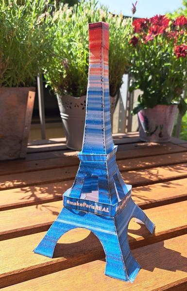 Das Foto zeigt einen gebastelten Eiffelturm in den Farben der Warming Stripes mot der Beschriftung #MakeParisReal
