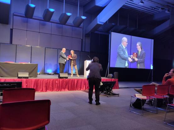 Steffen Neumann receiving an honorary membership to the metabolomics society from Roy Goodacre in Osaka, with commemorative plaque.