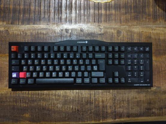 My keyboard with the new caps on. It's a regular 100 % Cherry MX board. The numblock still has the original white keycaps. Three keys are replaced with colourful custom keys, one showing the mechanicon logo