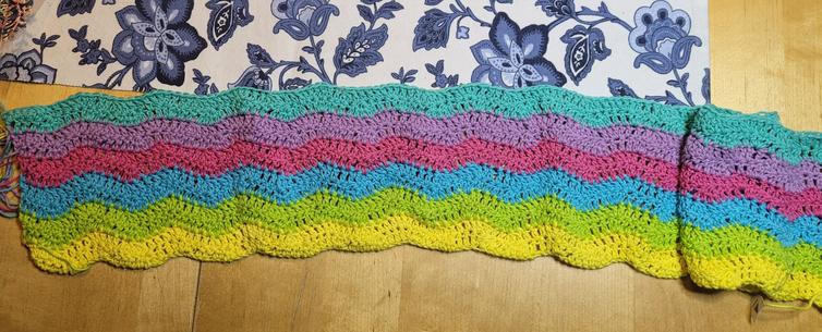 Rainbow baby blanket in progress with yellow, lime, turquise, cerise, lilac and mintgreen  wavy rows.