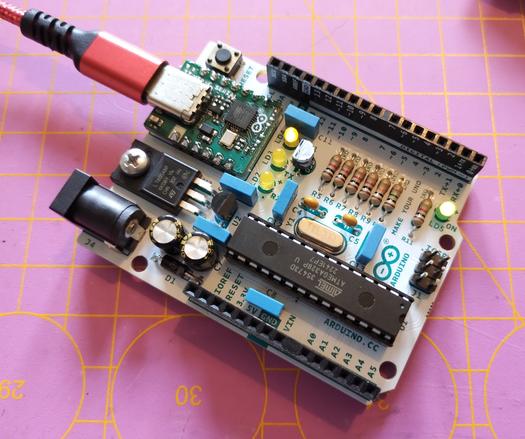 the Arduino Uno connected to a USB C power supply. the green power LED is lit, and one of the three yellow LEDs is blinking. the photo was taken while the blinking LED was lit.