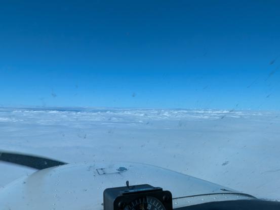 View out front of Cessna Skyhawk (small propeller airplane) from 6000' above sea level. Nothing but an ocean of clouds is visible looking forward. Skies above are clear