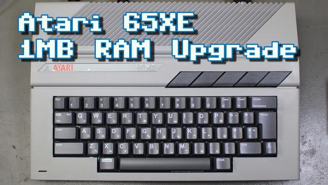 Thumbnail image for my new video. It shows a top down photo of my Atari 65XE with a dark grey DecentXE replacement keyboard. The text overlay reads "Atari 65XE 1MB RAM Upgrade".