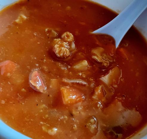 Bowl of tomatoes based, homemade Manhattan clam chowder soup.