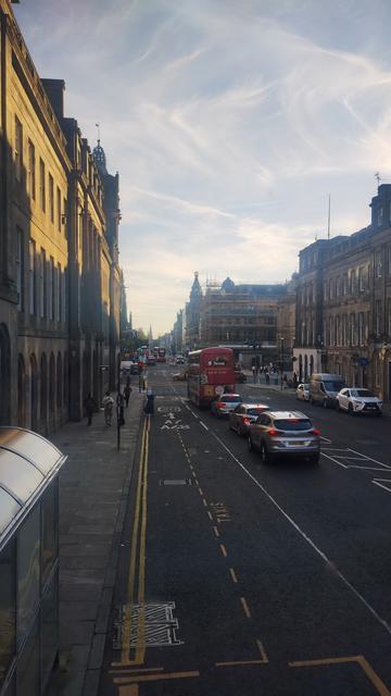 View from front of the upper deck of the double decker bus, looking west as sunset approaches, from Waterloo Place towards Princes Street
