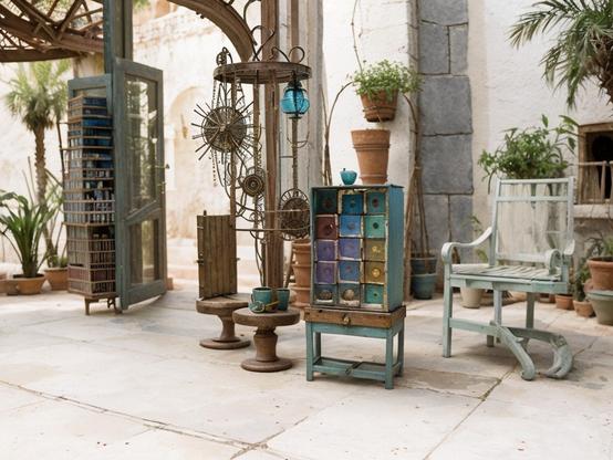 Outdoor pop-up tea shop, on a sidewalk, not open yet, with eclectic furniture, a tea cabinet with colorful drawers, and a relaxed, rustic setting in an open-air space.