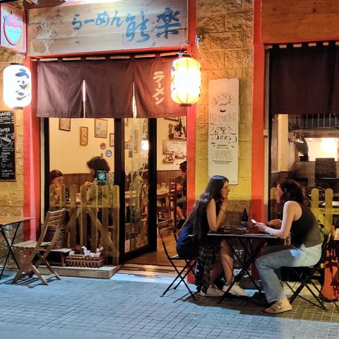Una pareja sentada en la terraza de un restaurante japonés en una calle del centro de Málaga.