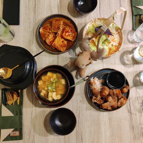 Mr Moose stuffy about to enjoy his meal for two: clockwise from left: covered bowl with rice, dragon tofu, salad, vegan pork belly, kimchi soup