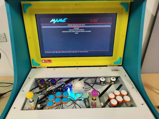 Collapsable teal and yellow arcade cabinet, set up for two players and trackball