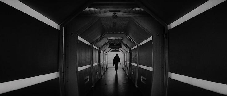 An astronaut passing a perfectly symmetrical walkway, similar to the ones seen in Kubrick's 2001: A Space Odyssey (1968). DP: Jan Kališ.
