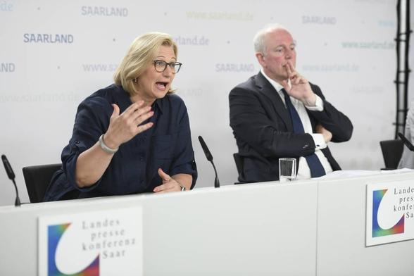 Die saarländische Ministerpräsidentin Anke Rehlinger und der saarländische Finanzminister Josef von Weizsäcker auf der Landespressekonferenz Saar.
Rehlinger hält die rechte Hand vor den Körper und schaut mit aufgerissenen Augen und Mund nach vorne, während v. Weizsäcker deutlich weniger aufgeregt in lockerer Pose daneben sitzt und zwei Finger an den Mund hält.

Kontext: Pressekonferenz anlässlich der Erkenntnis aus dem Zensus 2022, dass die Einwohnerzahl des Saarlandes auf über 1.000.000 gestiegen ist und das Land ca. 200.000.000 Euro an Mehreinnahmen erwarten kann.

Foto: Becker&Brendel via "Saarbrücker Zeitung"