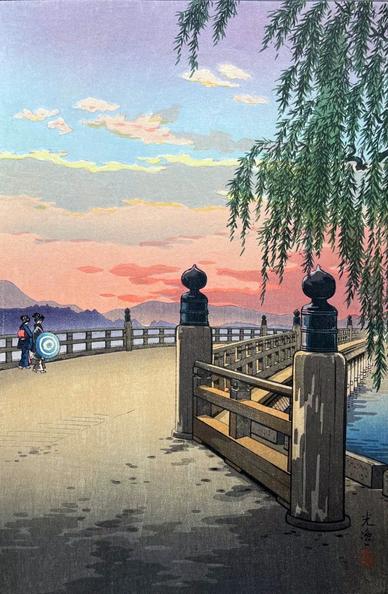 The sun sets over the Seta no Karahashi Bridge in Otsu. The sky displays a range of soft colours - from pale purple and blue high above, descending through a band of golden-edged back-lit clouds, before settling into pink and coral at the horizon. In the foreground, a pair of female figures in traditional clothing cross the wide Seta no Karahashi Bridge. On the right, a willow tree grows at the edge of the river, its leafy green branches reaching over the railing of the bridge and casting shadows across the road.