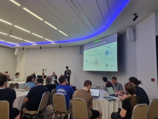 Amazing and happy looking computer scientist presenting to a room of professionals.