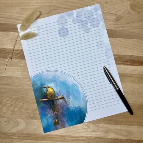 Photograph of a piece of stationery paper on a wooden surface, posed with a pen and a dried sprig of foxtail.
