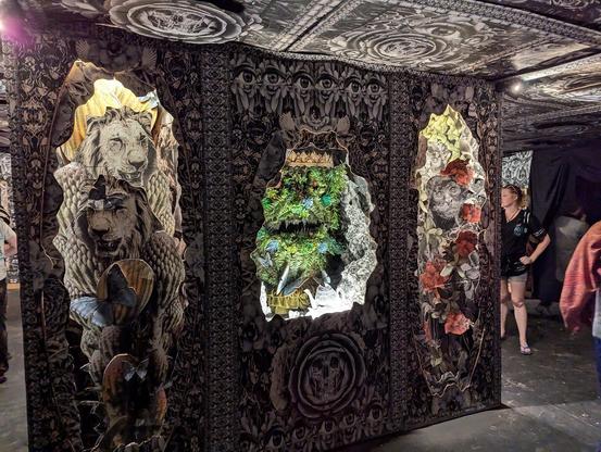 A dark indoor 'window' with floral and eyeball patterns.  Inside each window are collages of goats, monkeys and a strange eyeball monster.