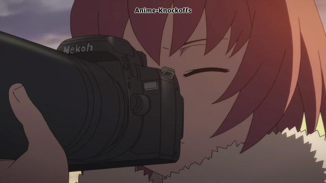 A red haired girl holding a big Nekoh camera