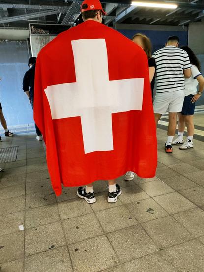 Fussballfan mit Schweizer Flagge am Rücken