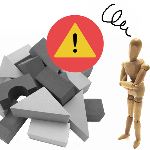 An error sign over a pile of assorted blocks, as a confused wooden mannequin looks on.