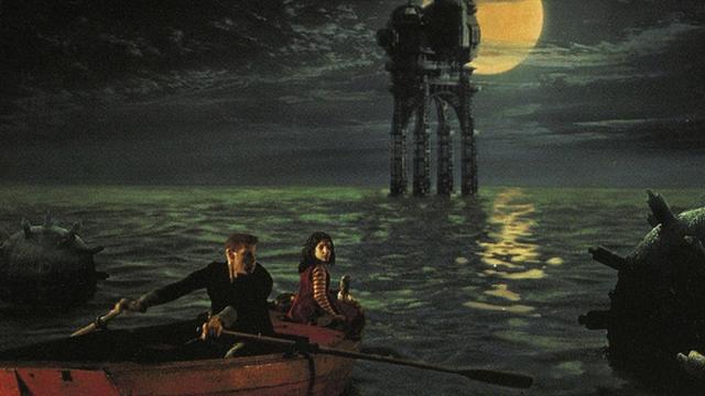 Circus strongman One (Ron Perlman), rowing a young girl across a mine-infested sea to a dark, industrial Gothic looking oil rig, in a scene from the French film La Cite Des Enfants Perdus