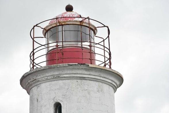 Le phare rouge est entouré de barres de fer. L'ensemble consolide la lumière permettant aux bateaux de naviguer.