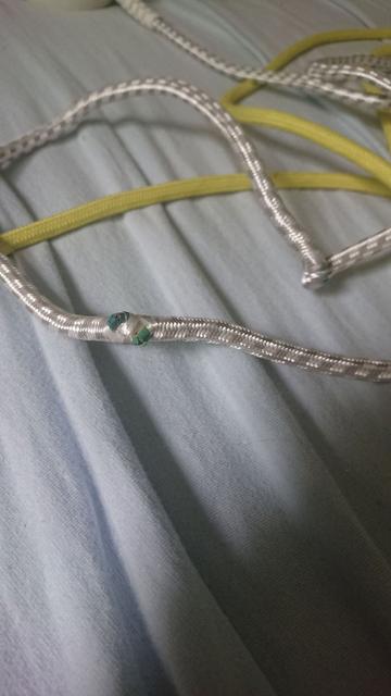 Weißes Stoffkabel mit kaputten Stellen und gelbes intaktes Stoffkabel