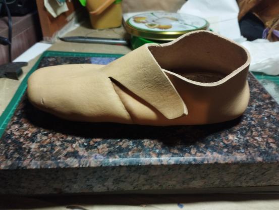 A photo of a very basic closed leather shoe in a vaguely  medieval style.