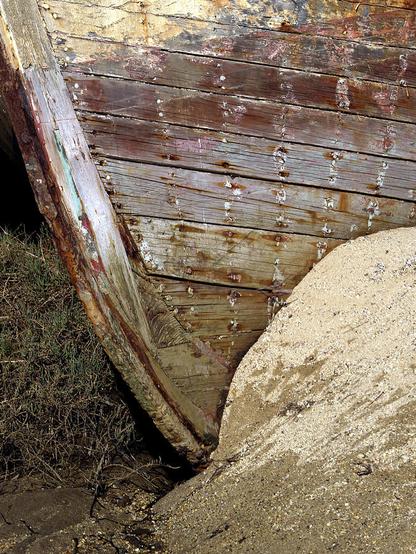 Pt Reyes Abstract

This is a closeup of the bow of a ship that ran aground many years ago called the Pt Reyes.
The left foreground and side of the image is green grass that sits on the edge of Tomales Bay. 
The right foreground and side of the image is sand from the small sand dune that captured this boat during a winter storm.
The subject is the bow of the Pt. Reyes. The wood on this but is all but completely missing as years of weathering have stripped the boat bare. Whay drew me to this is that even after all these years you can see how craftsmen built this boat.