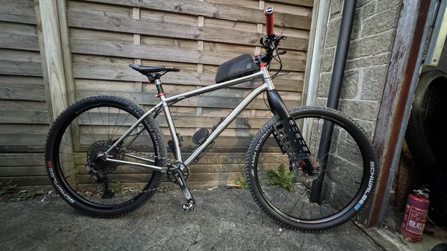 Picture of a Titanium Sonder Broken Road mountain bike leaning against a fence.
