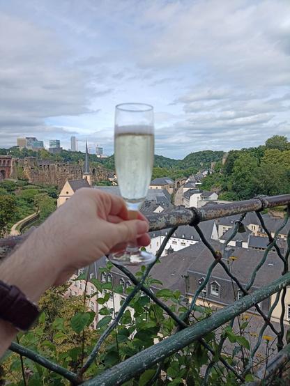 Saying cheers with a glass of Crement in luxembourg City while overlooknig Grund and the European Quarter.