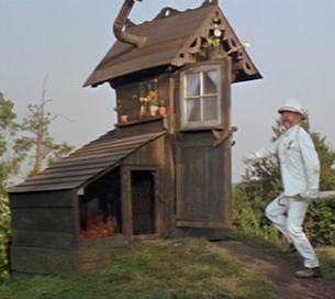 Lionel Jeffries as Grandpa Potts, approaching his beloved shed dressed in a white suit and pith helmet. He wears his service medals and carries a white umbrella.