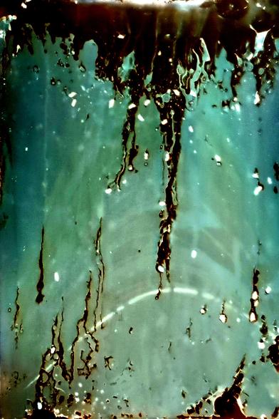 An almost abstract image of the sun's arcs with rivulets of water damage and specks of ants all over.